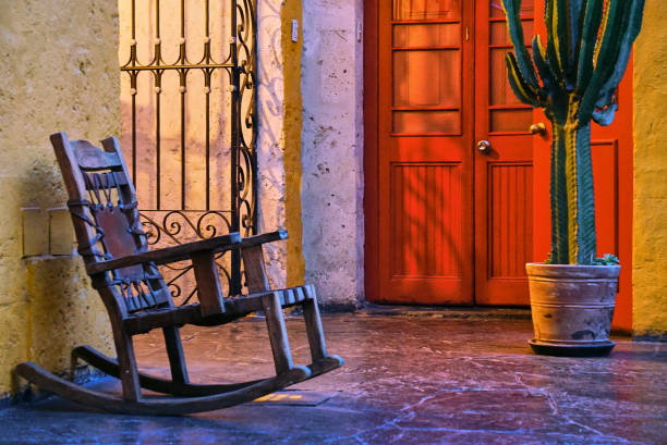 Empty Rocking Chair and a Cactus A house facade in Arequipa, Peru, with a rocking chair, a door  and a cactus arequipa province stock pictures, royalty-free photos & images