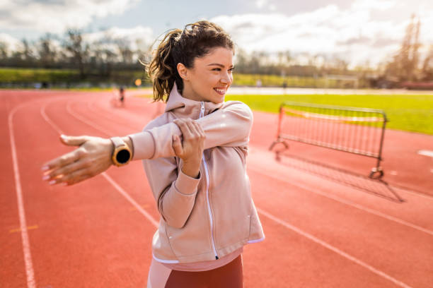 sportliche junge frau, die sich auf der laufstrecke aufwärmt. - running track women running spring stock-fotos und bilder