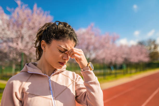 頭痛を持つスポーティな若い女性 - running track women running spring ストックフォトと画像