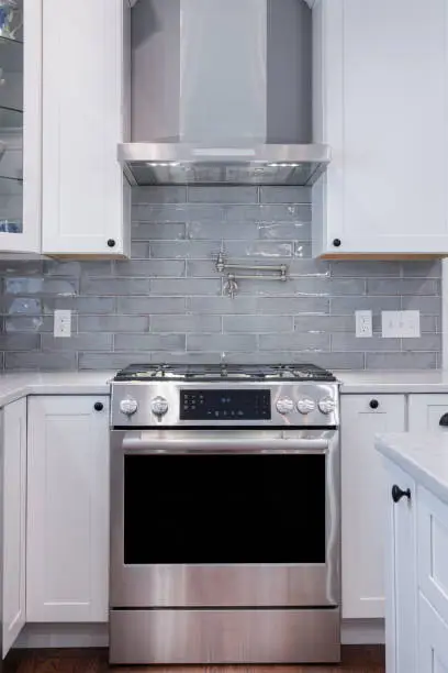Photograph of a kitchen gas stove and oven with vent hood