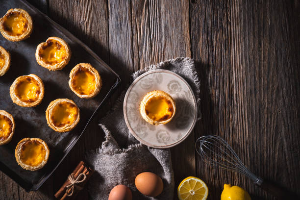 Belem cakes or Pasteis de Belem, Portuguese traditional recipe pastel de Nata Custard Tarts Belem cakes or Pasteis de Belem, Portuguese traditional recipe pastel de Nata Custard Tarts with ingredients on rustic wooden table portuguese culture photos stock pictures, royalty-free photos & images
