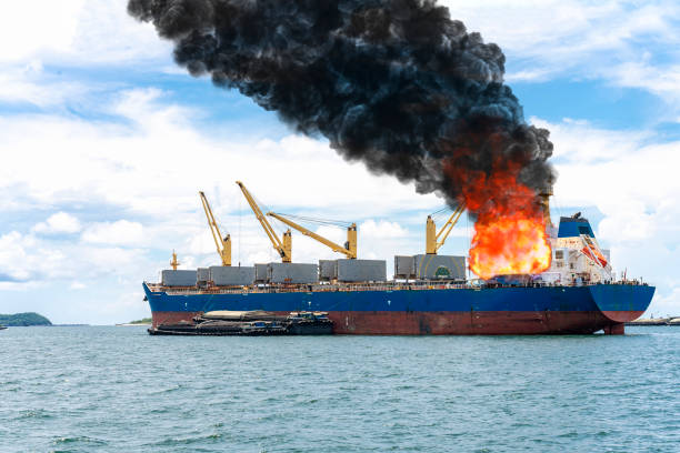 Large general cargo ship for logistic import export goods and other the explosion and had a lot of fire and smoke at sea in bright day stock photo