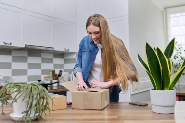 istock Young happy woman unpacking cardboard boxes, unboxing expected postal parcel 1308309421