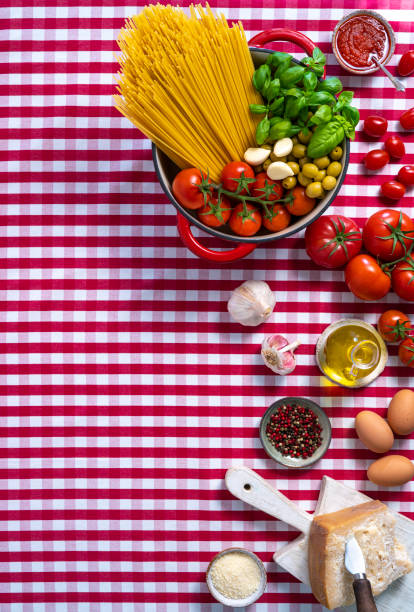 istock Spaghetti basil tomato garlic and olives in pot on gingham tablecloth 1308311049