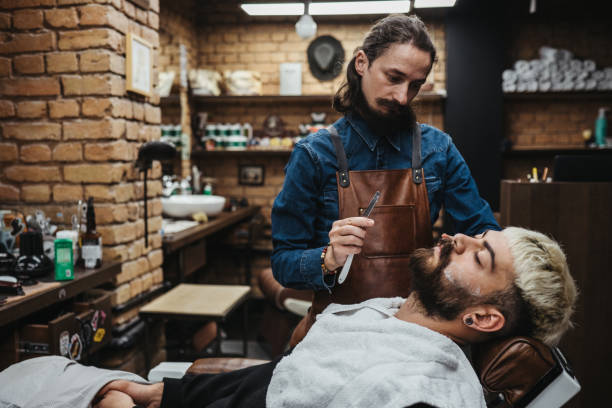 istock Barber Giving A shaving in His Shop 1308316107