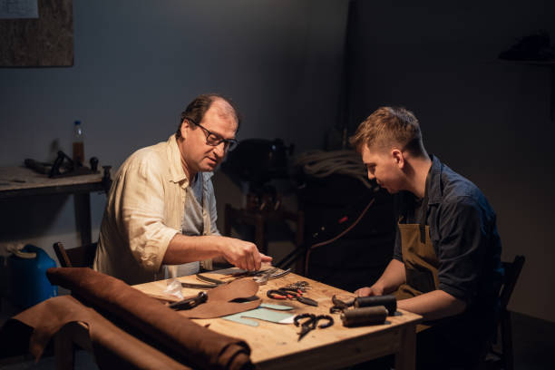 istock an elderly shoemaker and his apprentice create shoes by hand in their workshop with various tools 1308316369