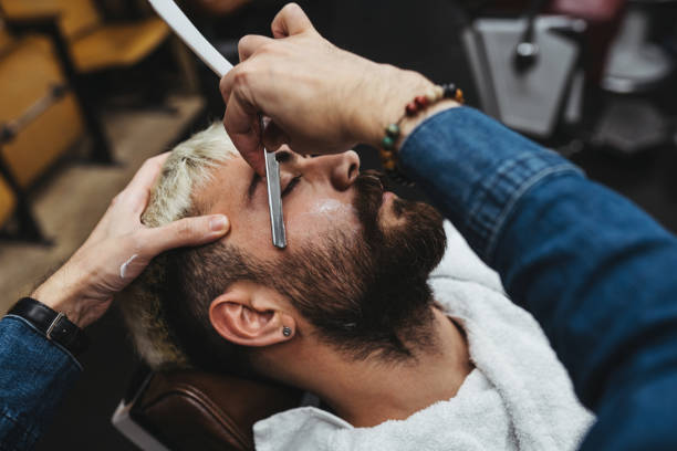 istock Barber Giving A shaving in His Shop 1308316910