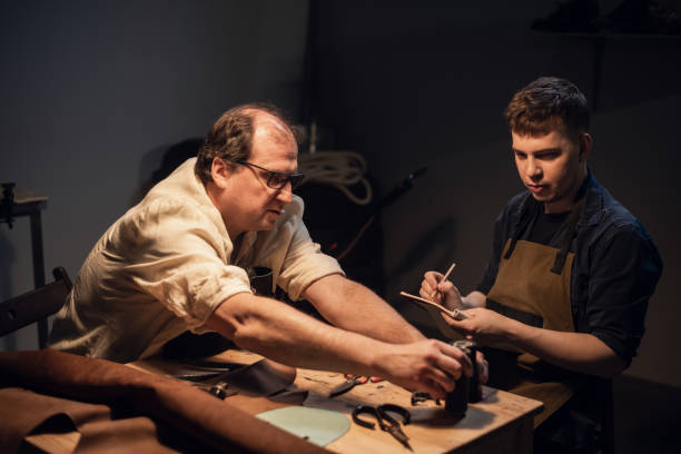 istock a respectable elderly shoemaker conducts a master class for a young boy on making shoes by hand in a special workshop 1308316991