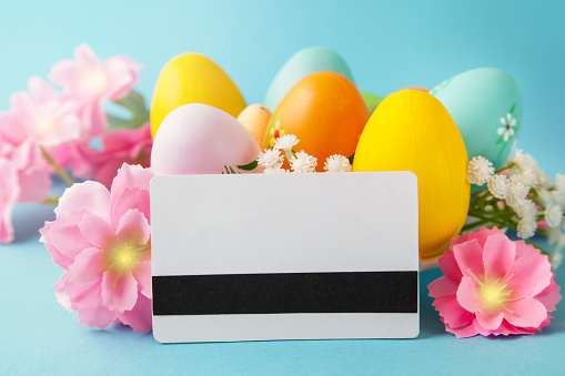 Shopping online. Ordering Easter. Easter eggs, credit card on blue background. Online store. Sale concept