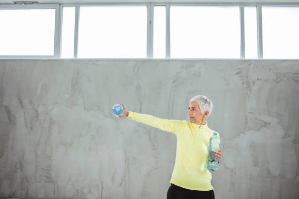 istock Senior Woman doing workout with two water bottles 1308318535