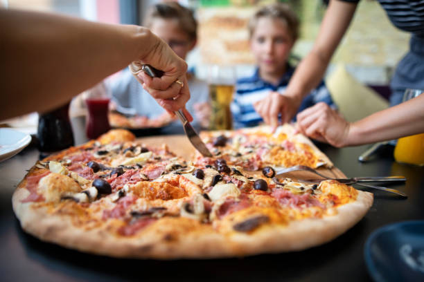Kids enjoying pizza at a restaurant Kids are eating huge pizza and drinking juice at the restaurant. Focus on the pizza.
Nikon D850 kids restaurant pictures stock pictures, royalty-free photos & images