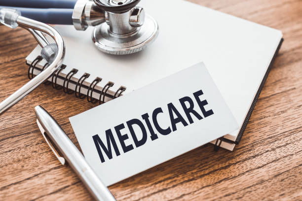 MEDICARE - text on card on wooden table with stethoscope and notepad for medical records. MEDICARE - text on card on wooden table with stethoscope and notepad for medical records. medicare stock pictures, royalty-free photos & images