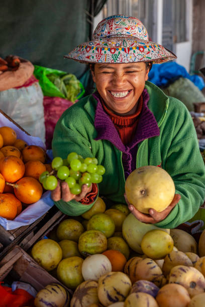 mujer peruana vendiendo frutas en su tienda, chivay, perú - trajes tipicos del peru fotografías e imágenes de stock