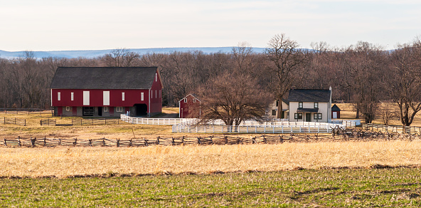 Gettysburg, Pennsylvania, USA March 13, 2021 A farm house and red barn on the battlefield at Gettysburg National Military Park on a sunny spring day