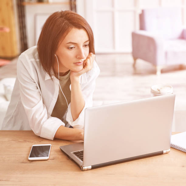 istock Young woman sitting at home. Working on notebook 1308332942