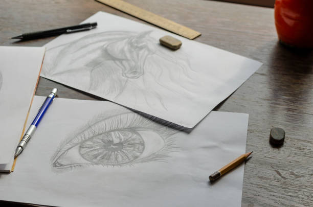 istock Drawings made by a pencil lie on a brown wooden table. 1308334619