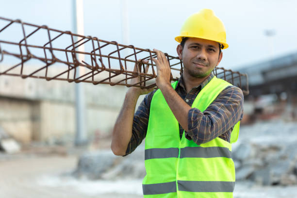 asian construction worker carrying steel in construction site stock photo