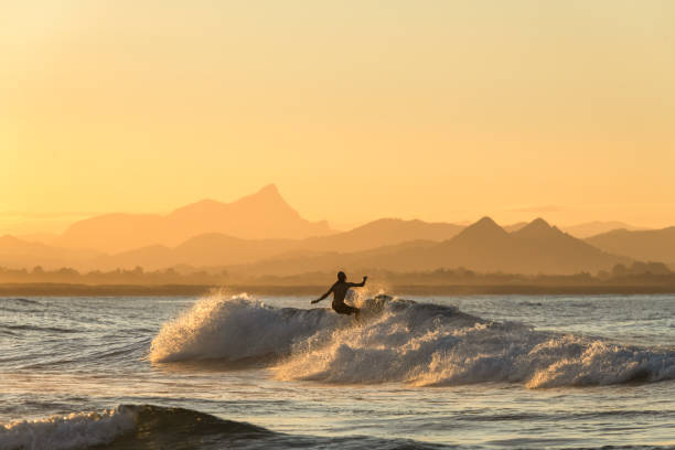 surfen bei sonnenuntergang - surfen stock-fotos und bilder