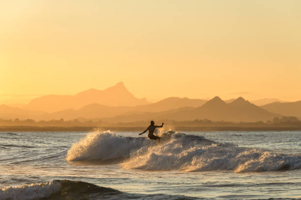 Surfing  at sunset Surfing  at sunset, Byron Bay Australia surf stock pictures, royalty-free photos & images