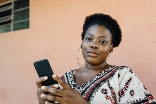 istock Black woman with smartphone in hand looking at camera 1308348099
