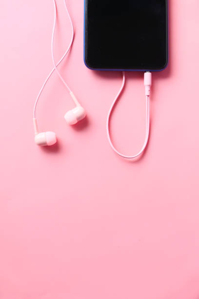 istock smart phone and headphone on pink background . 1308349932