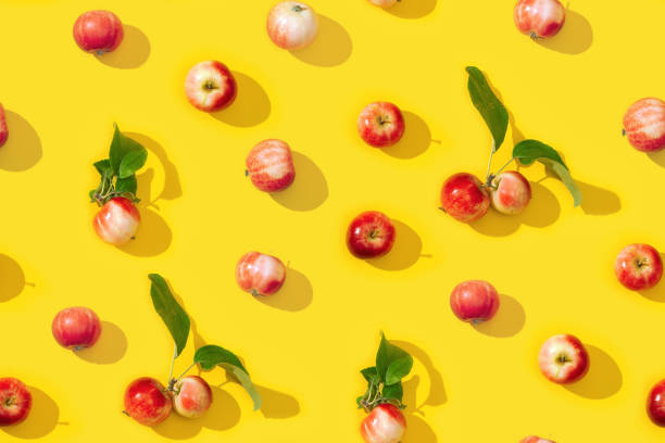 istock Seamless creative pattern from small red apples and green leaves with dark shadows. 1308350718