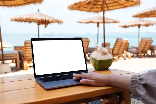 istock a woman using and touching on laptop touchpad with blank desktop screen while sitting on the beach 1308355099