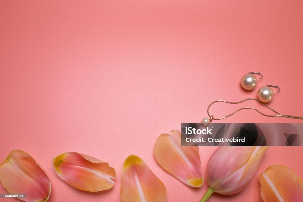 Beauty background with jewelry and petals, with free space for text. Modern beauty layout, top view, flat lay. Elegant background and template for your design. Flower Stock Photo