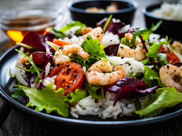 istock Prawn salad - prawns with white rice and vegetables on wooden table 1308365367