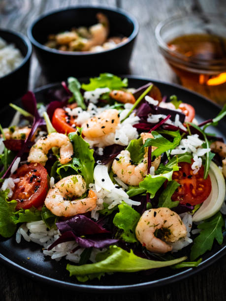 istock Prawn salad - prawns with white rice and vegetables on wooden table 1308365371
