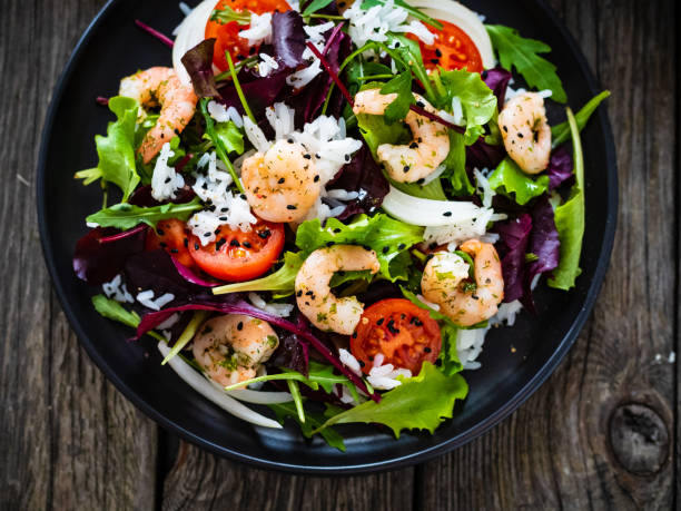 istock Prawn salad - prawns with white rice and vegetables on wooden table 1308365419