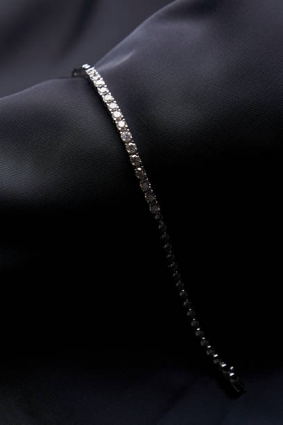 istock Platinum bracelet with diamonds on black silk background 1308369242