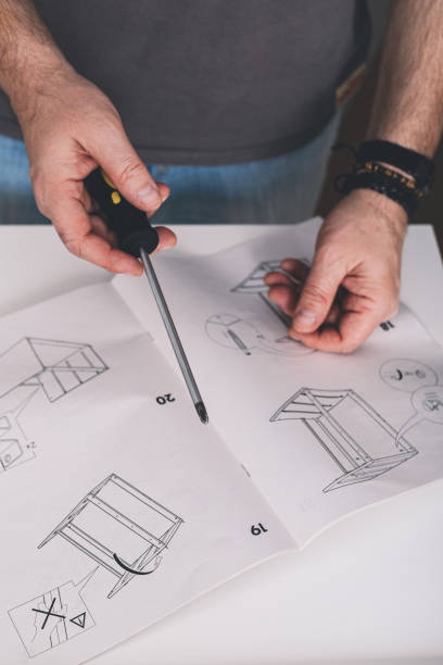 istock Mans hands holding a screwdriver. Furniture assembling. Housework. Vertical shot 1308370946
