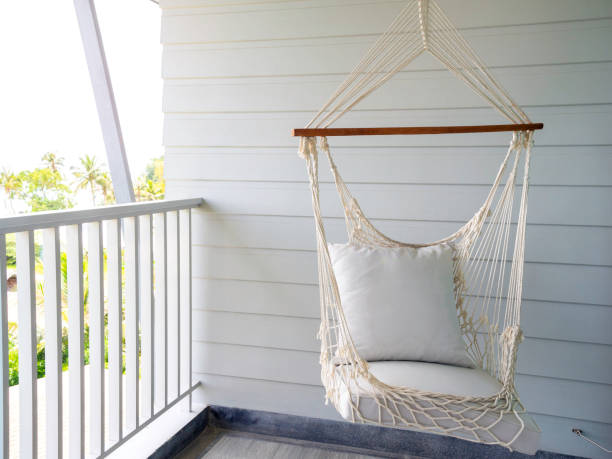 istock Empty white knitting rope swing hanging from ceiling on white wood background. 1308371352