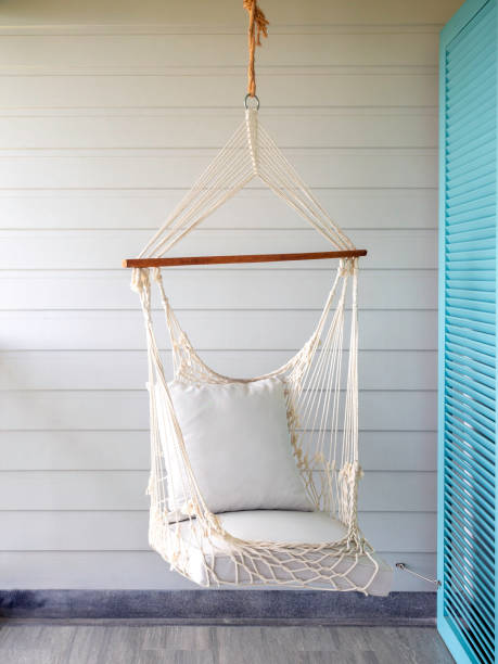 istock Empty white knitting rope swing hanging from ceiling on white wood background. 1308371360