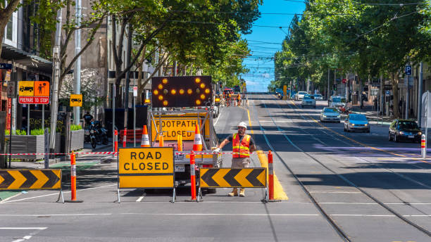 mężczyzna ma na sobie odzież hi visibility podczas załogi drogi zamkniętej stacji - melbourne australia sign road zdjęcia i obrazy z banku zdjęć