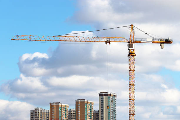 istock Construction crane and residential buildings on blue sky and white clouds background 1308374261