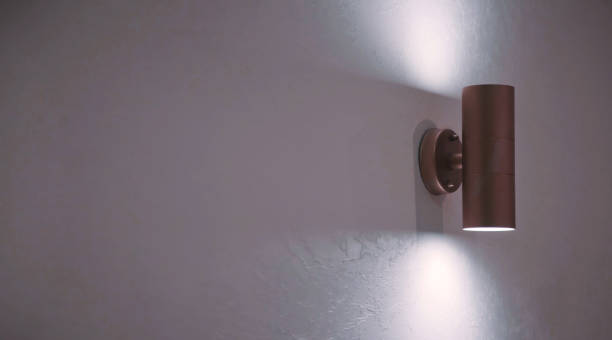 istock Stylish modern lamp on white textured wall 1308374377
