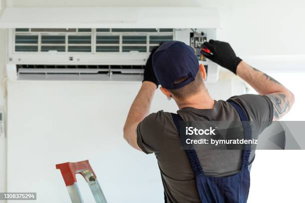 Technician Repairing Air Conditioner Stock Photo - Download Image Now - Air Conditioner, Repairing, Air Duct