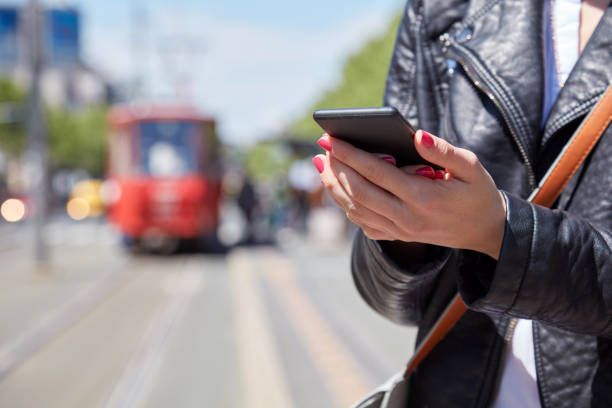 istock Woman using cellphone on a tram station in Europe. 1308377902