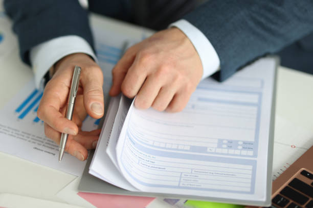 istock Businessman holds pen and stretches application form 1308380769