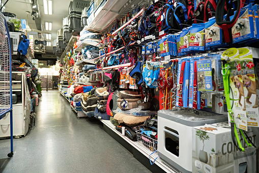 View of unoccupied aisle with large group of animal care merchandise for sale on either side.