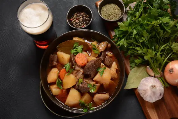 Photo of Irish stew made with beef, potatoes, carrots and herbs. Traditional St.Patrick's day dish, stewed in dark Guinness beer