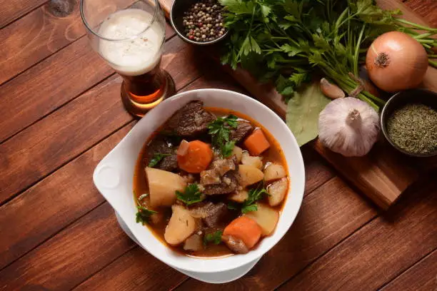 Photo of Irish stew made with beef, potatoes, carrots and herbs. Traditional St.Patrick's day dish, stewed in dark Guinness beer