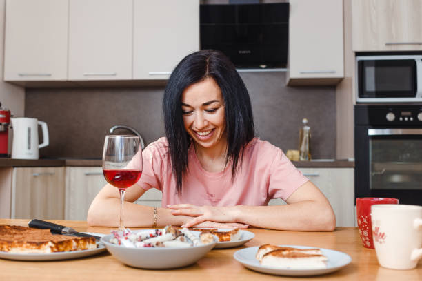 istock young dark-haired woman sits at the dining table in the kitchen 1308383148