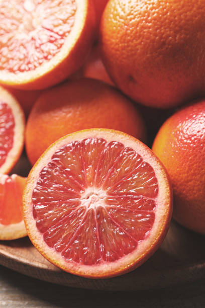 istock Whole and cut red oranges on wooden table, closeup 1308384215
