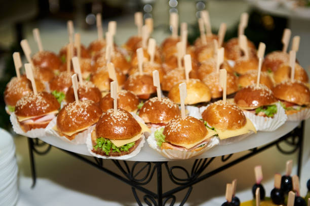 istock Buffet table with mini hamburgers at luxury wedding reception, copy space. Serving food and appetizers at restaurant. Catering banquet table 1308386458