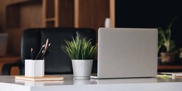 istock Laptop on office desk interior. Stylish workplace mockup 1308387659