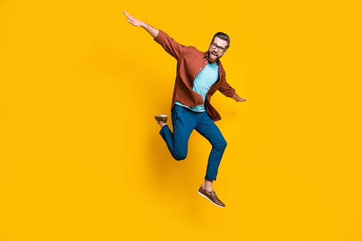 Full length body size photo of male student playful cheerful student laughing isolated on bright yellow color background