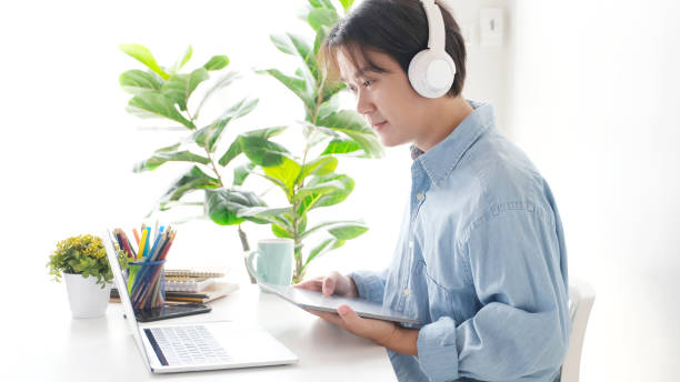 istock Video conference, Work from home, Asian man making video call to business team with virtual web while holding digital tablet, Contacting colleague by conference on laptop computer at home 1308391278